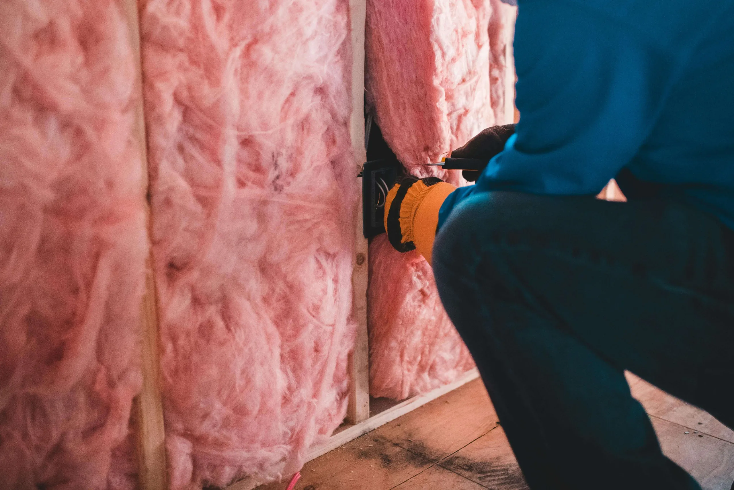 man installing insulation in the wall